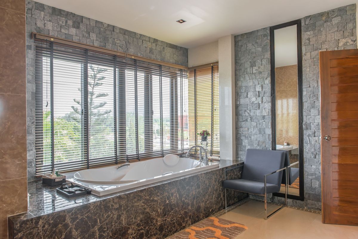Luxurious tub in a modern bathroom,side windows view,bright sunlight,sunny day