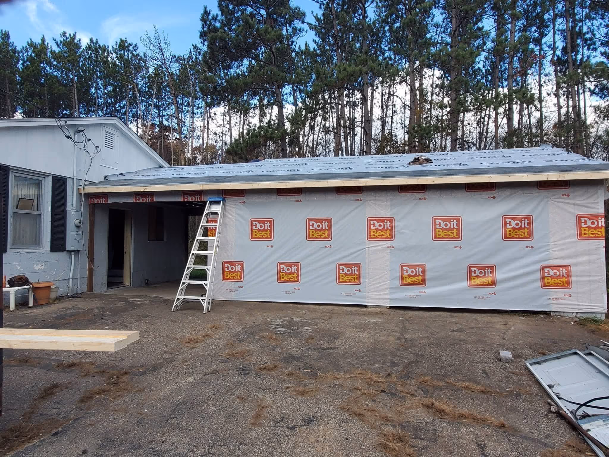 A house garage under construction with Do it Best branded sheathing and a ladder leaning on it.